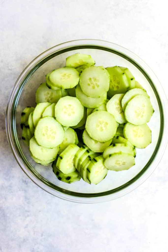 Salted cucumber slices in clear glass bowl
