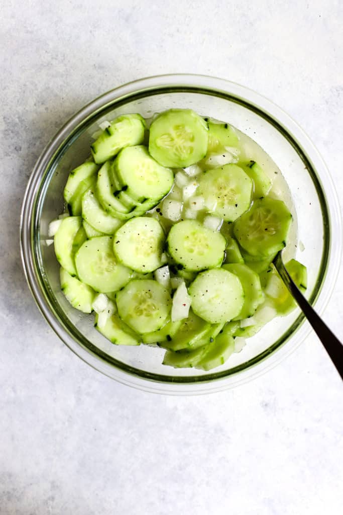 Vinegar cucumber salad in a bowl with a spoon.