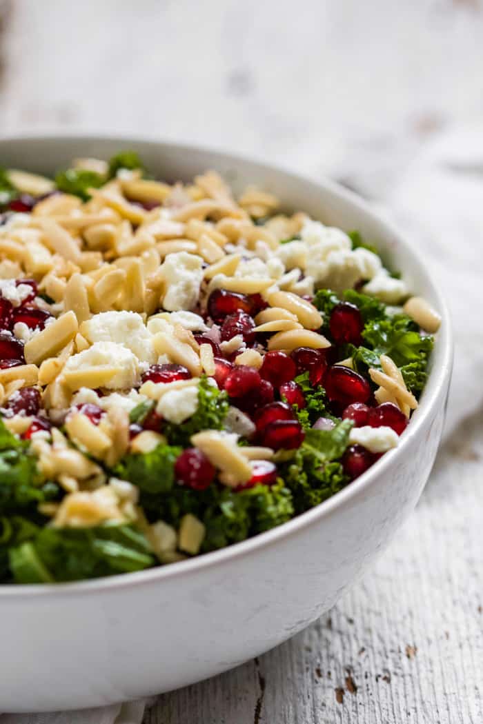 Kale, feta and pomegranate salad in a white bowl