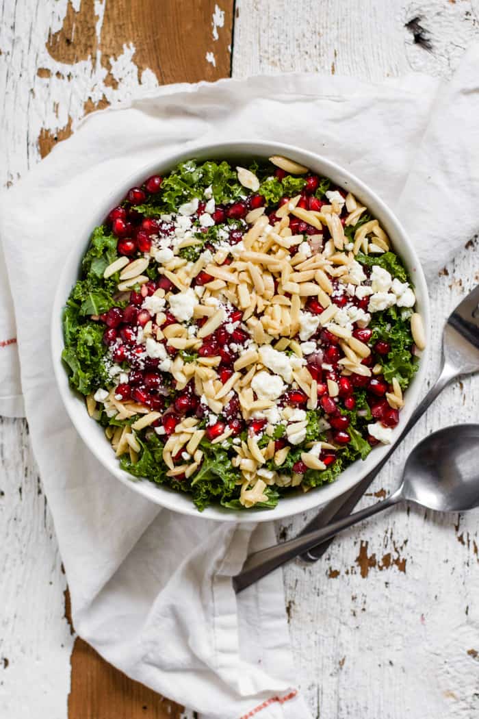 Kale, feta and pomegranate salad in a white bowl