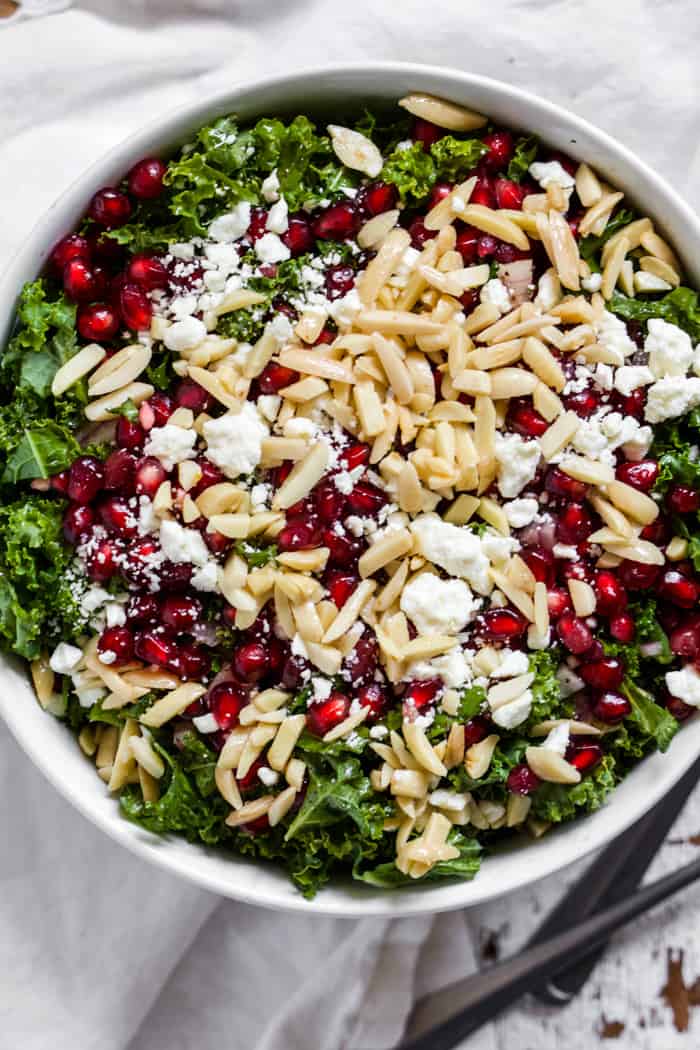 Kale, feta and pomegranate salad in a white bowl
