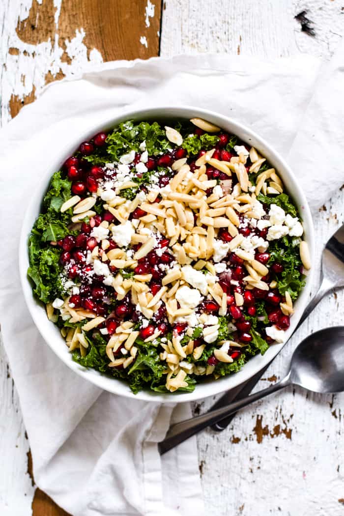 Kale, feta and pomegranate salad in a white bowl