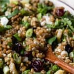 Wheat berry salad with wooden spoon.
