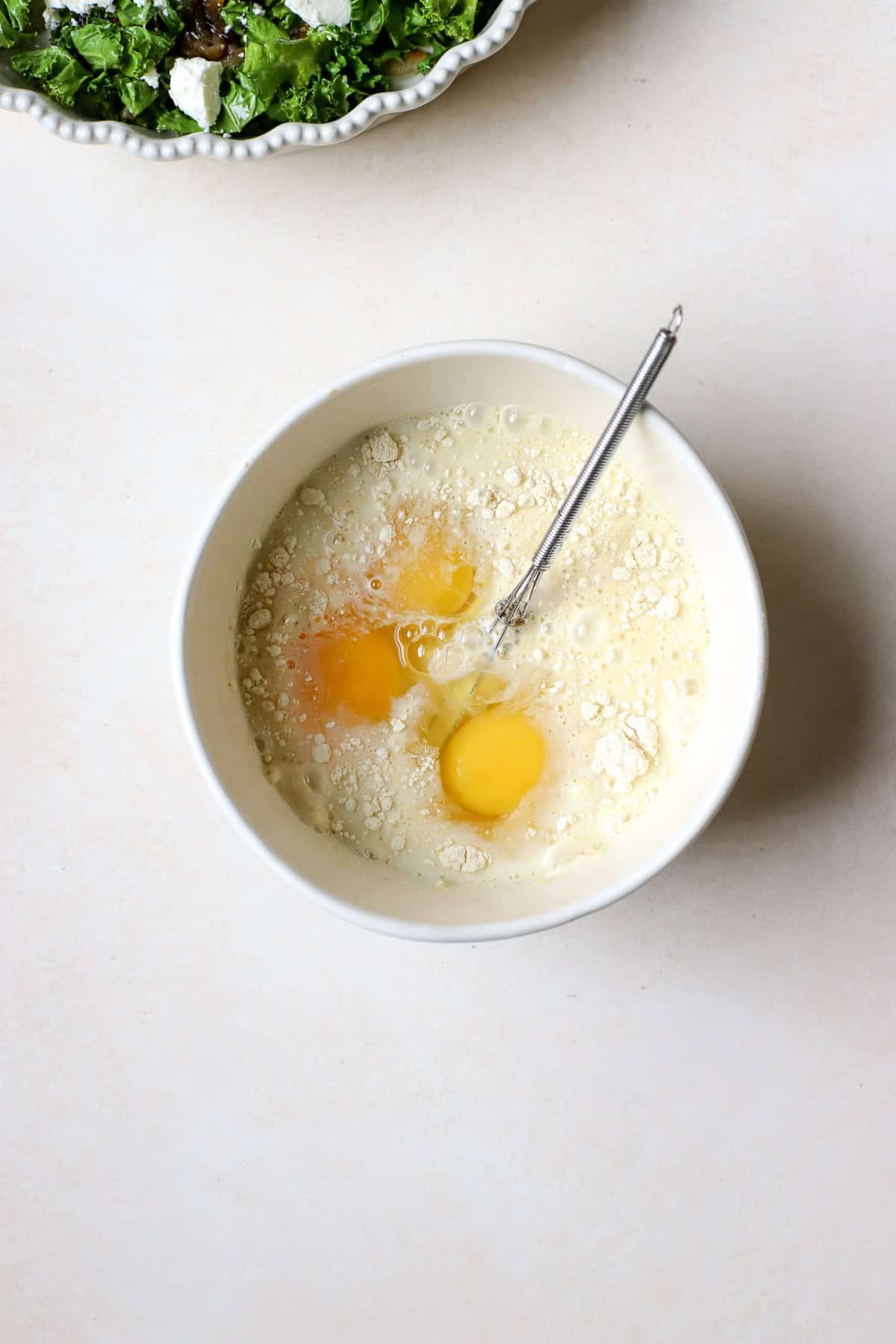 Eggs, chickpea flour, and baking powder being whisked together in bowl.