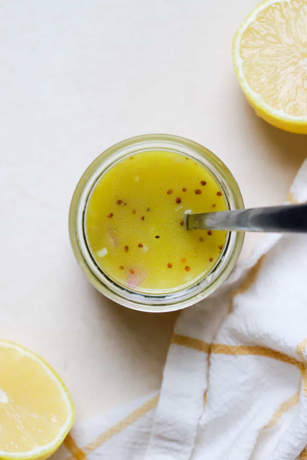Simple lemon vinaigrette in small jar.