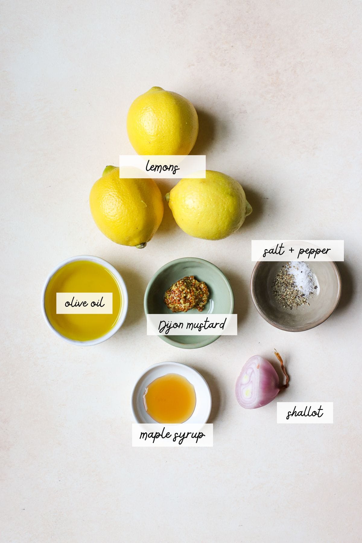 Lemons, olive oil, Dijon mustard, salt, pepper, maple syrup, and shallot.