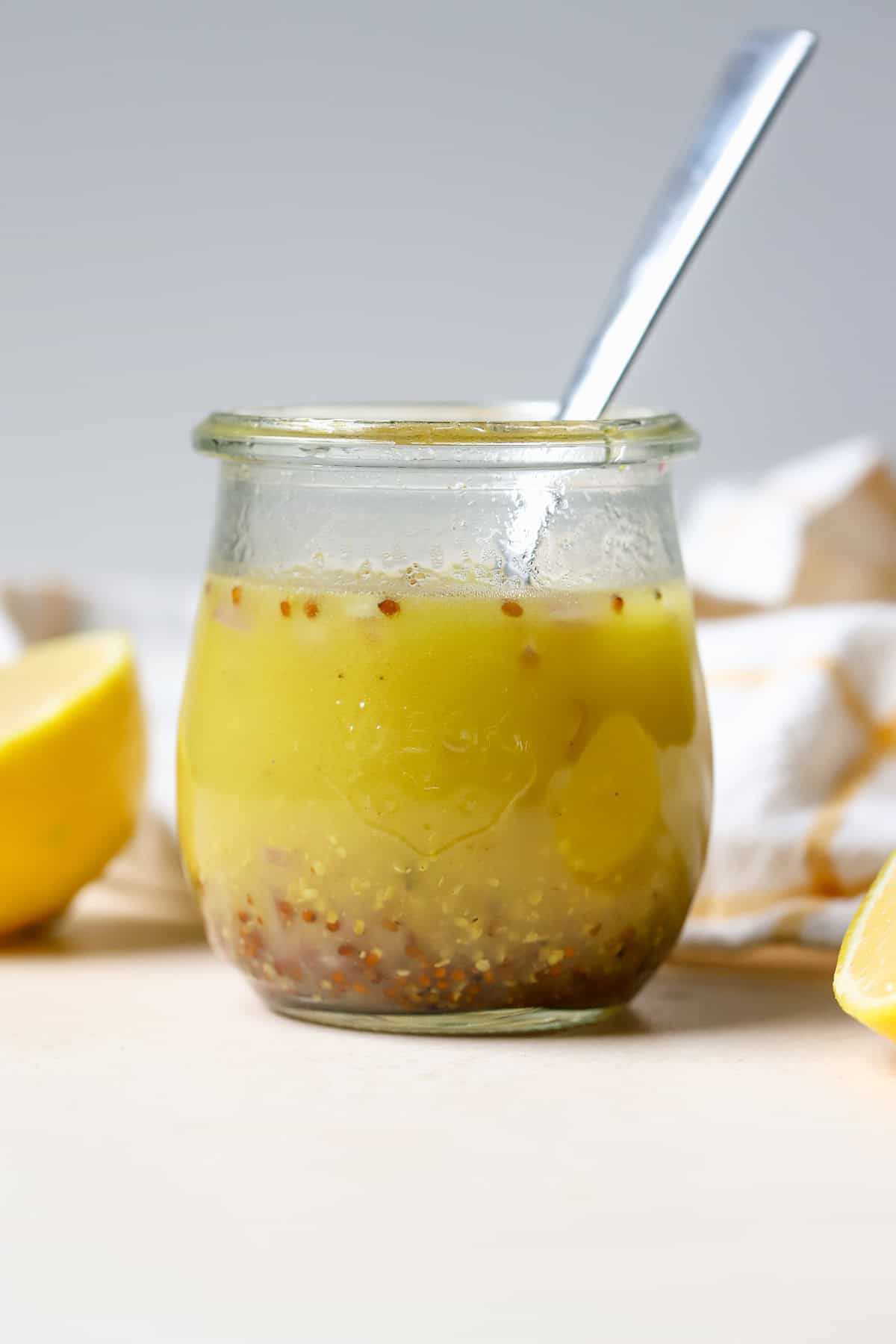 Simple lemon vinaigrette in small jar.