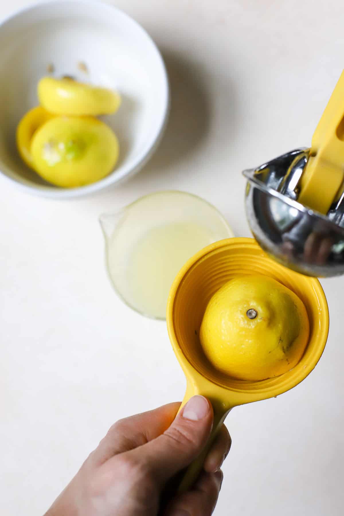 Lemon half being squeezed in lemon squeezer.