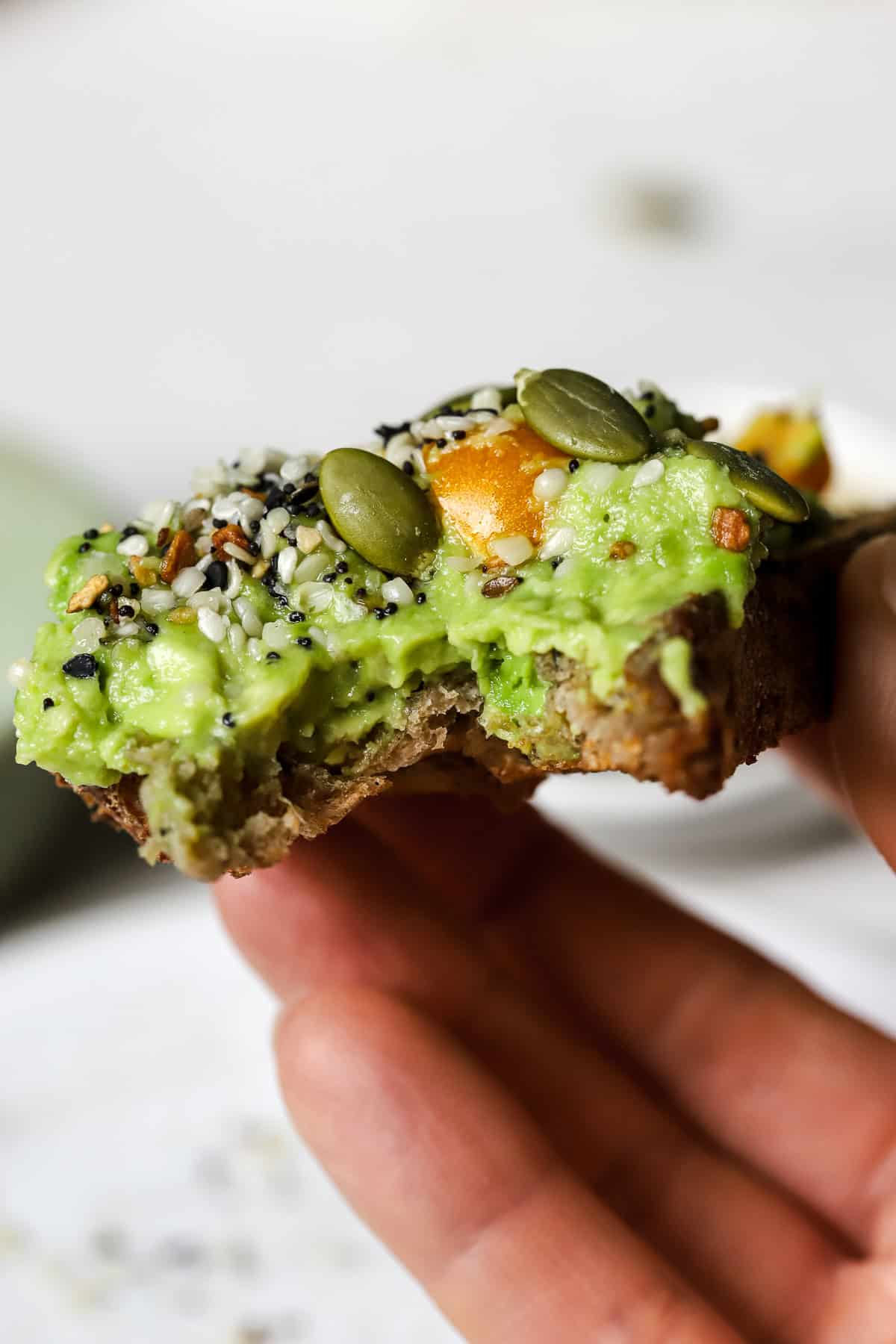 Avocado toast with bite taken out of it.