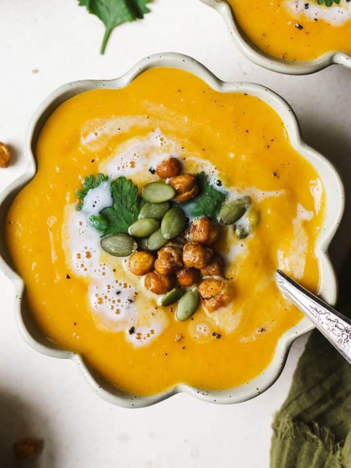 Thai butternut squash soup in a bowl with toppings.