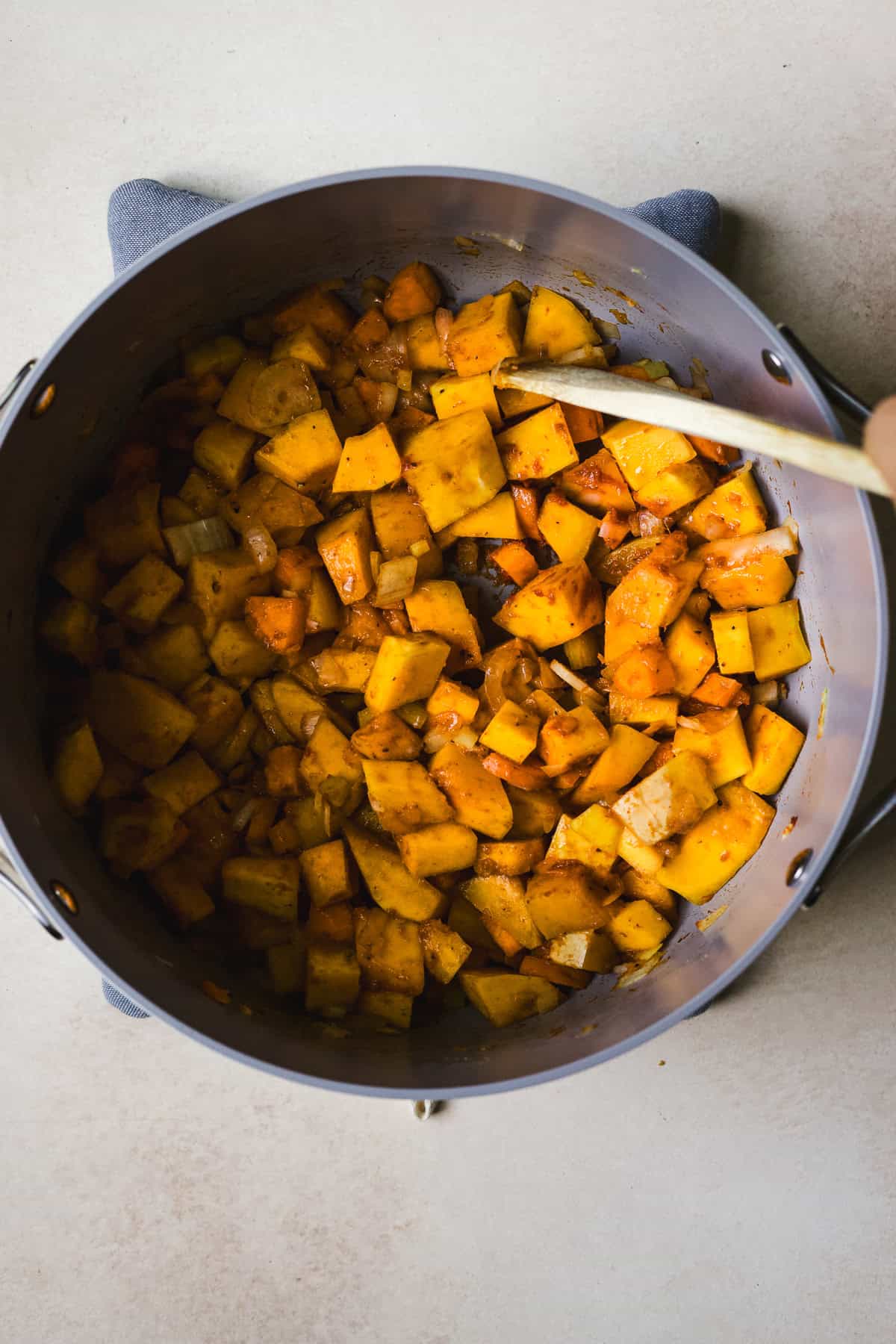 Sautéing aromatics in Thai red curry paste in a large soup pot.