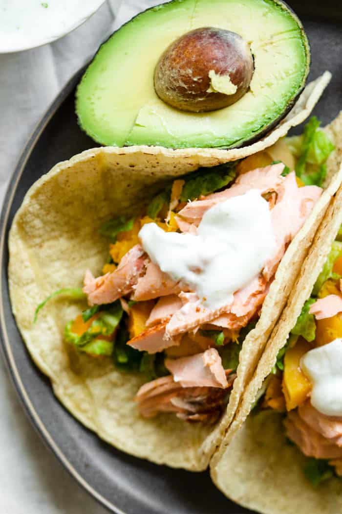 Smoky Salmon Butternut Tacos - Complete with lime crema! So simple, healthy, and flavorful. Sometimes you just need an easy weeknight meal during the busy holiday season. These tacos are it! Wild-caught salmon, smoked paprika, butternut squash, Brussels sprouts, lime crema. Come and try it out! | rootsandradishes.com