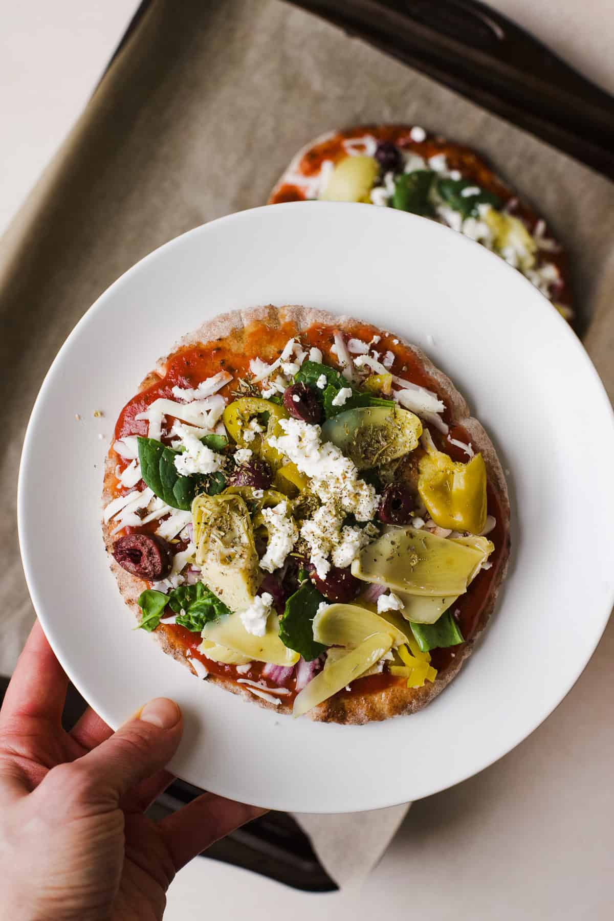 Pita pizza with all toppings, ready to be baked.