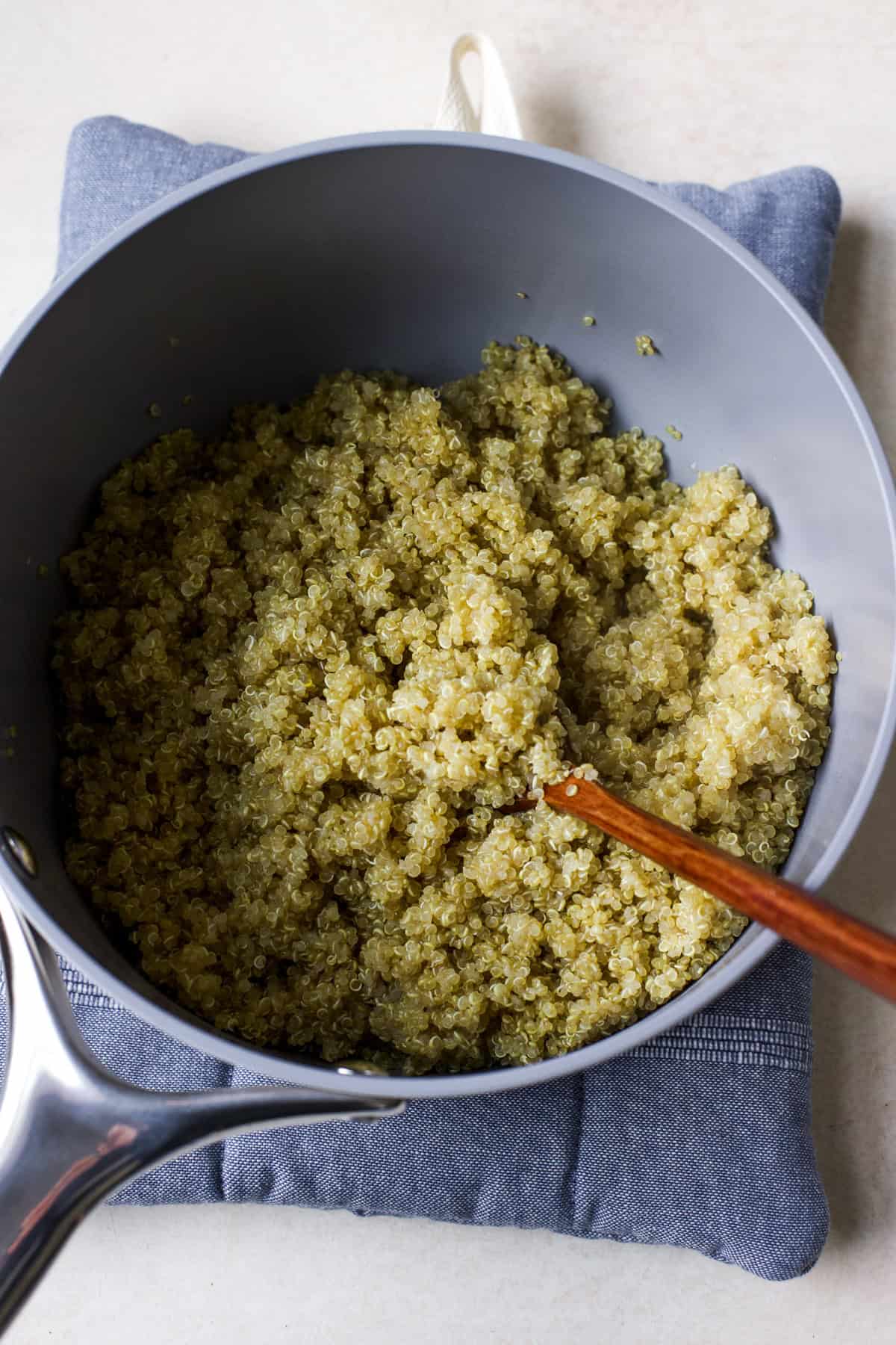 Fluffy quinoa in pot with spoon.