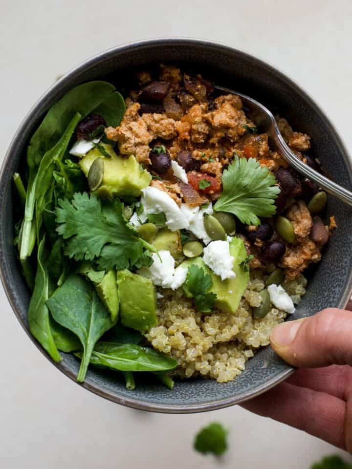 Quinoa bowls with turkey taco meat, greens, and toppings.