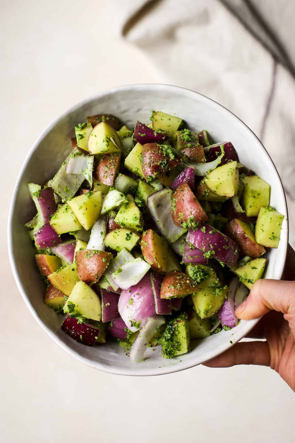 Potatoes seasoned with pesto in a bowl.