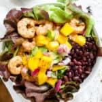 Chili lime shrimp in bowl with black beans and greens.