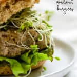 Close-up of turkey pesto walnut burger on sprouted grains roll with sprouts, lettuce, and avocado