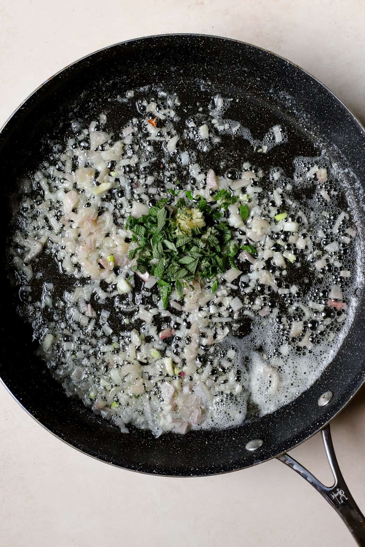 Sautéing shallots, garlic, and fresh sage in butter.