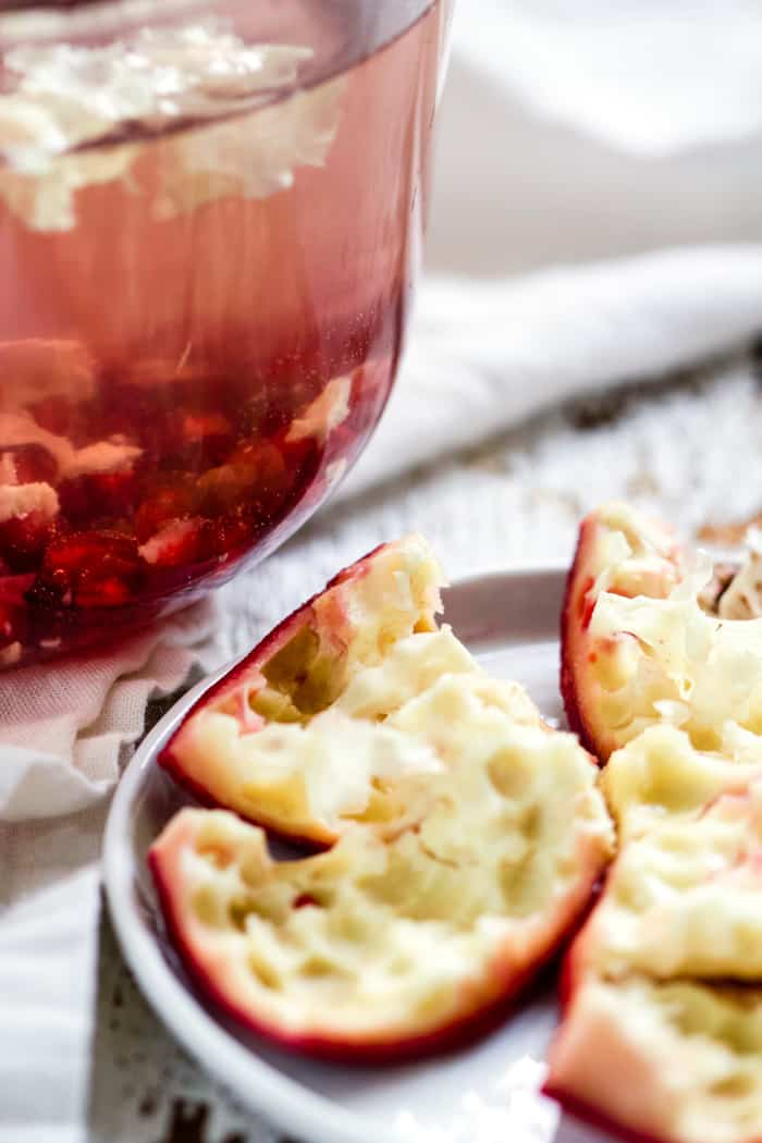 Deseeded pomegranate rind next to bowl of water