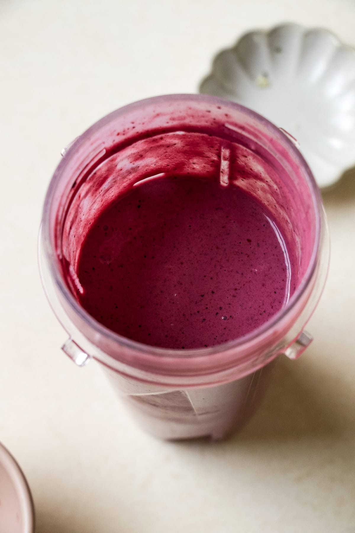Blended berry protein smoothie in blender container.