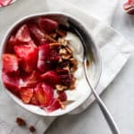 Blood orange maple pecan yogurt bowl in white bowl on white napkin