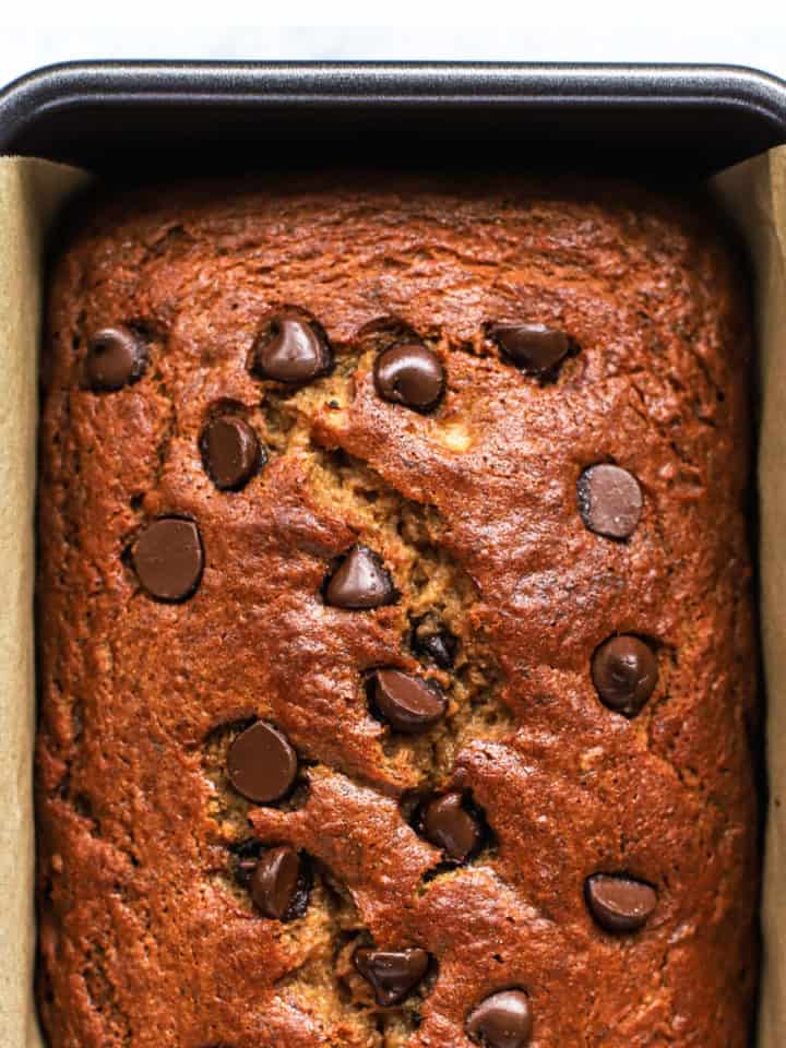 Spelt flour banana bread with chocolate chips in loaf pan lined with parchment paper