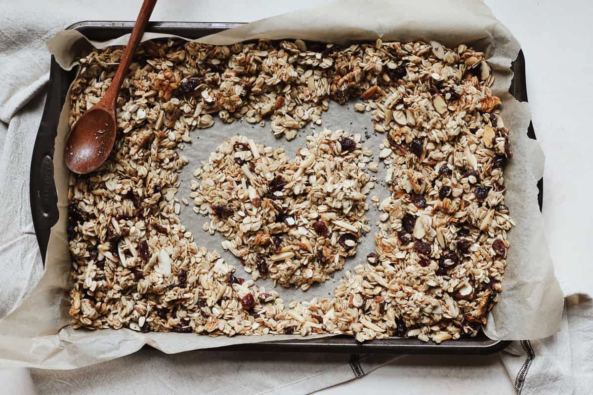 Heart drawn into cranberry almond granola on sheet pan.