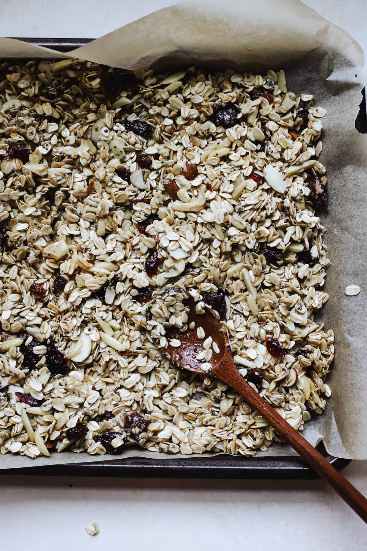 Spreading granola onto sheet pan before baking.