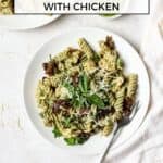 Pesto pasta salad with chicken on a white plate.