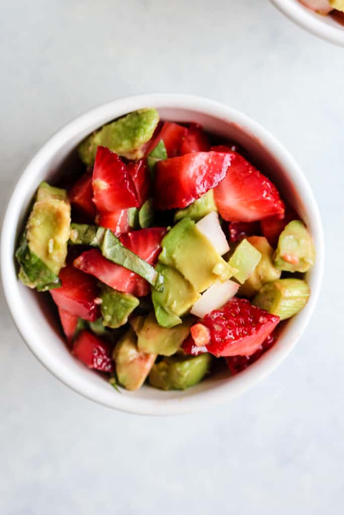 Strawberry avocado basil salsa in small white bowl