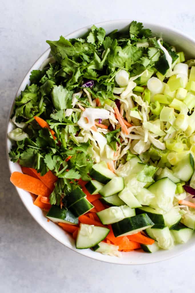 Thai peanut chicken salad veggies chopped in bowl before tossing