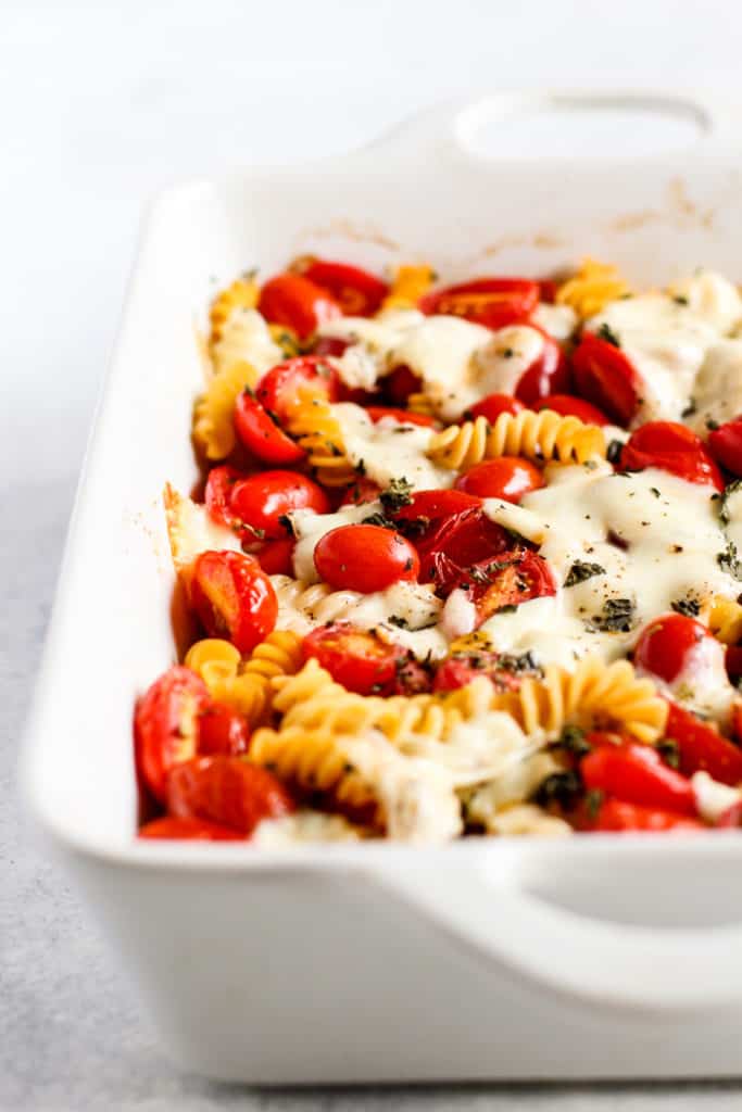 Simple caprese pasta bake in white ceramic dish