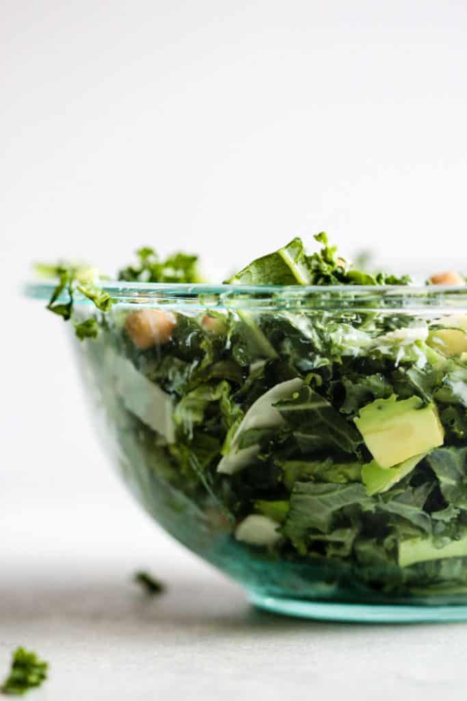 Creamy kale Caesar with avocado salad in clear bowl