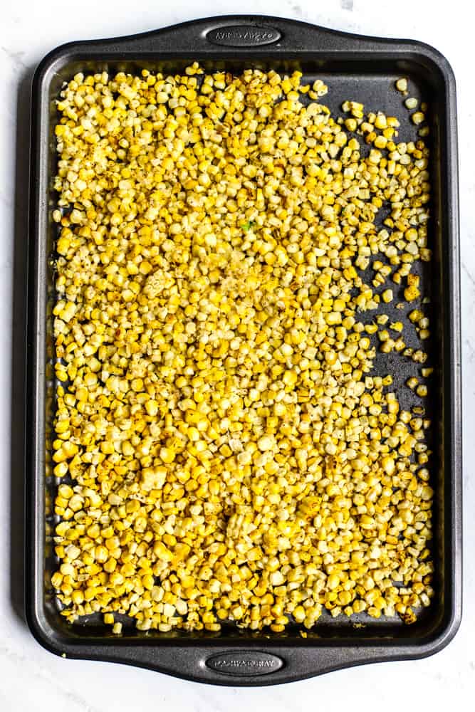 Roasted chipotle-spiced corn kernels after they were cut off the cob, on a sheet pan