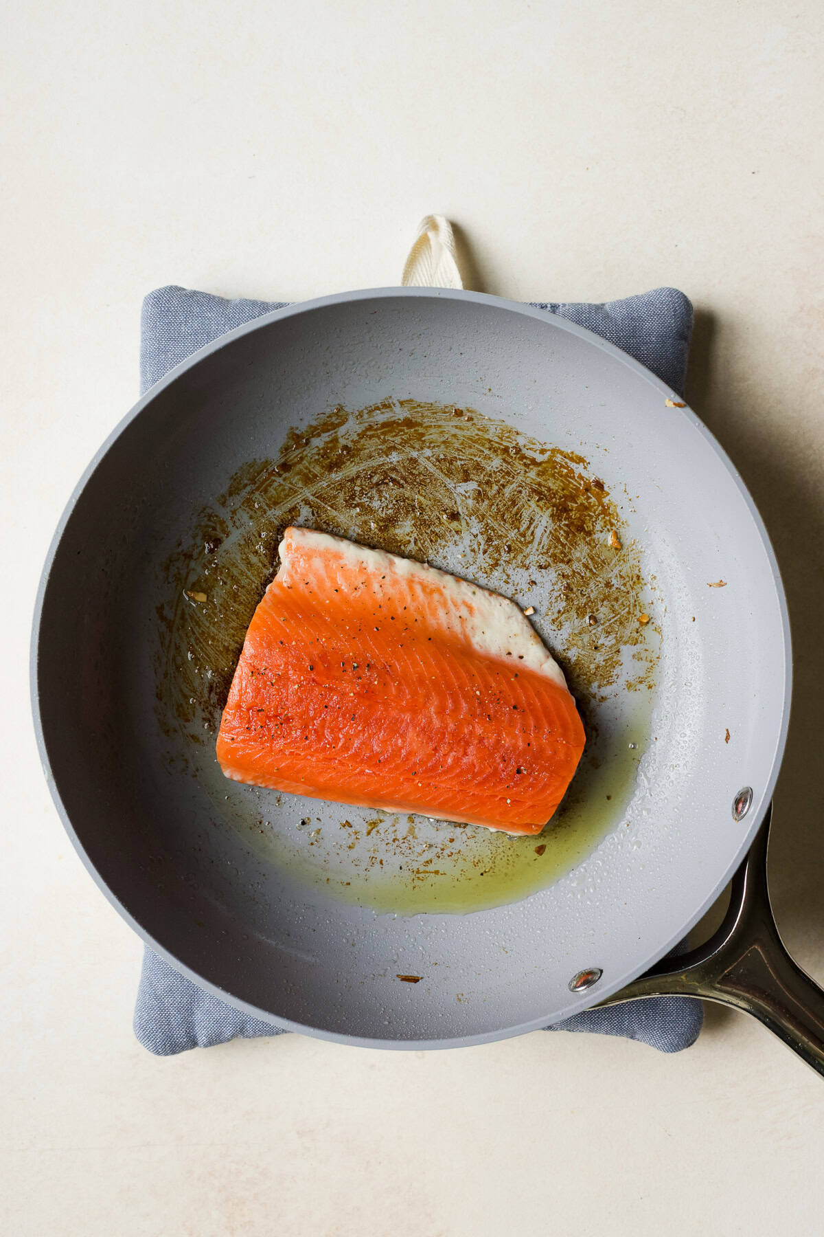 Placing salmon skin side down in pan for searing.