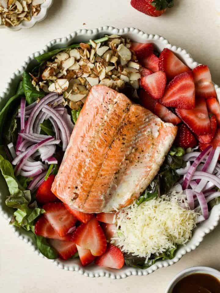 Strawberry salmon salad in white ceramic bowl.