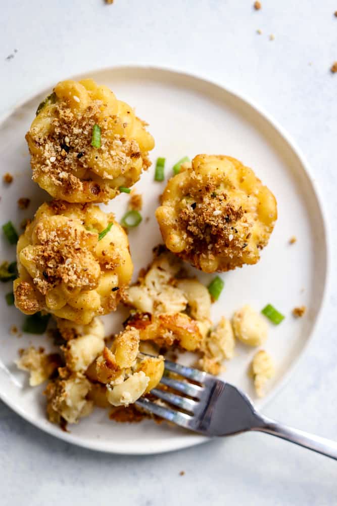 Healthy mac and cheese bites on white plate with fork