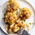Healthy mac and cheese bites on white plate with fork