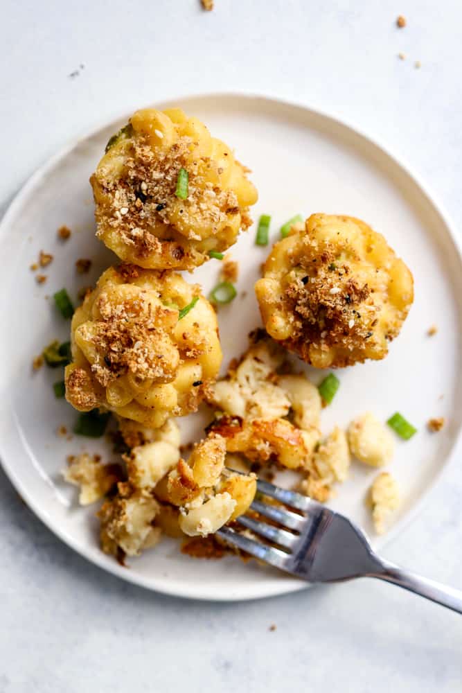 Healthy mac and cheese bites on white plate with fork