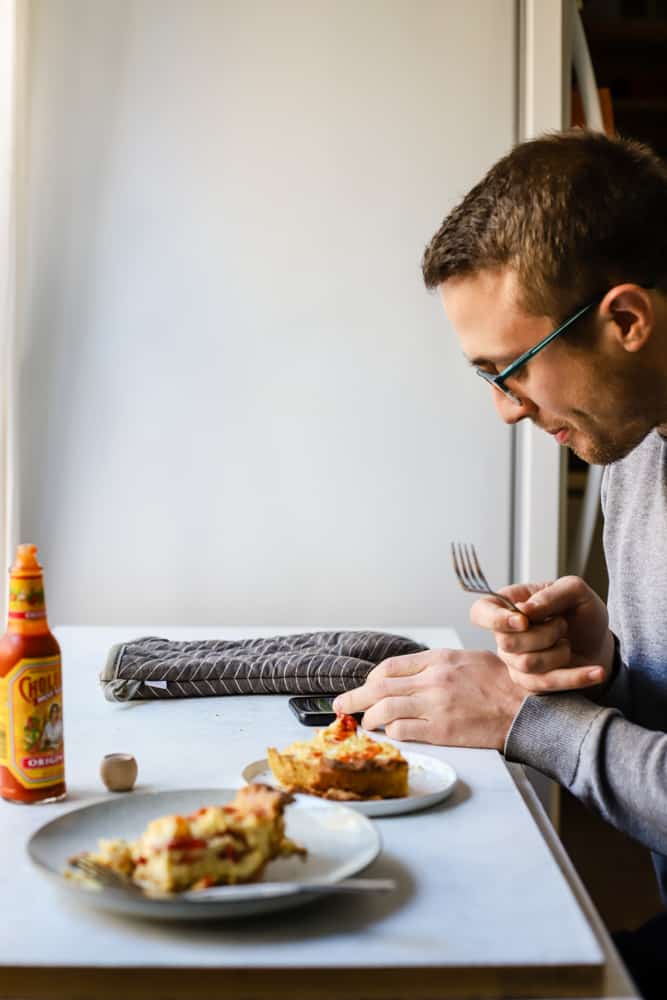 Two slices of pie crust being served with Cholula hot sauce, and my boyfriend at the table