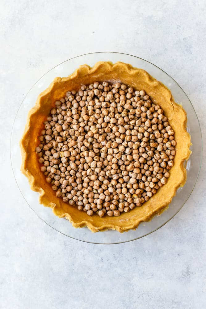 Dried chickpeas in a chickpea flour pie crust dough, about to be blind-baked