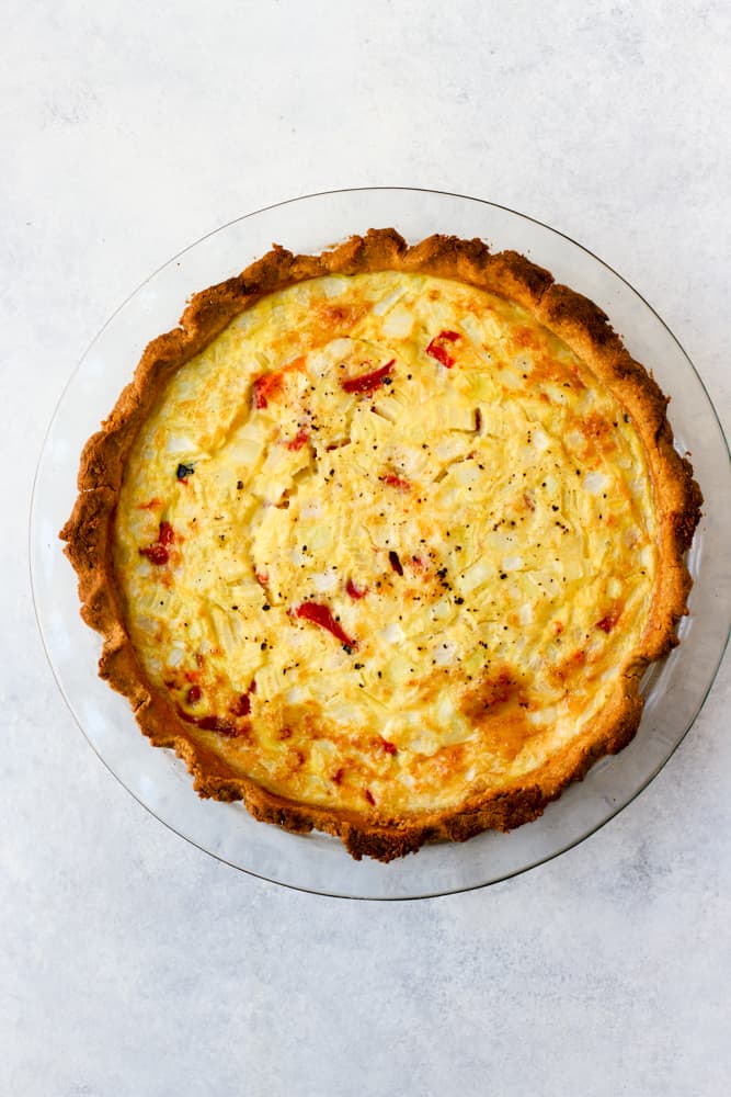 Simple quiche with chickpea flour baked in clear glass pie dish