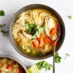 Ginger lime chicken soup with rice noodles in a bowl.