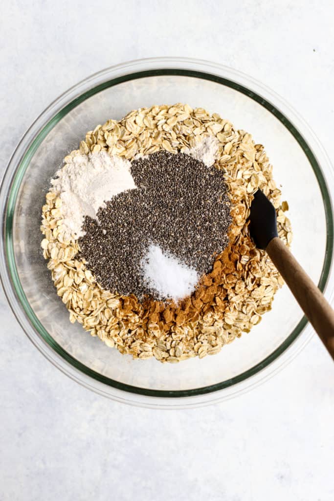 Oats, flour, chia seeds, cinnamon, and salt in a clear glass bowl