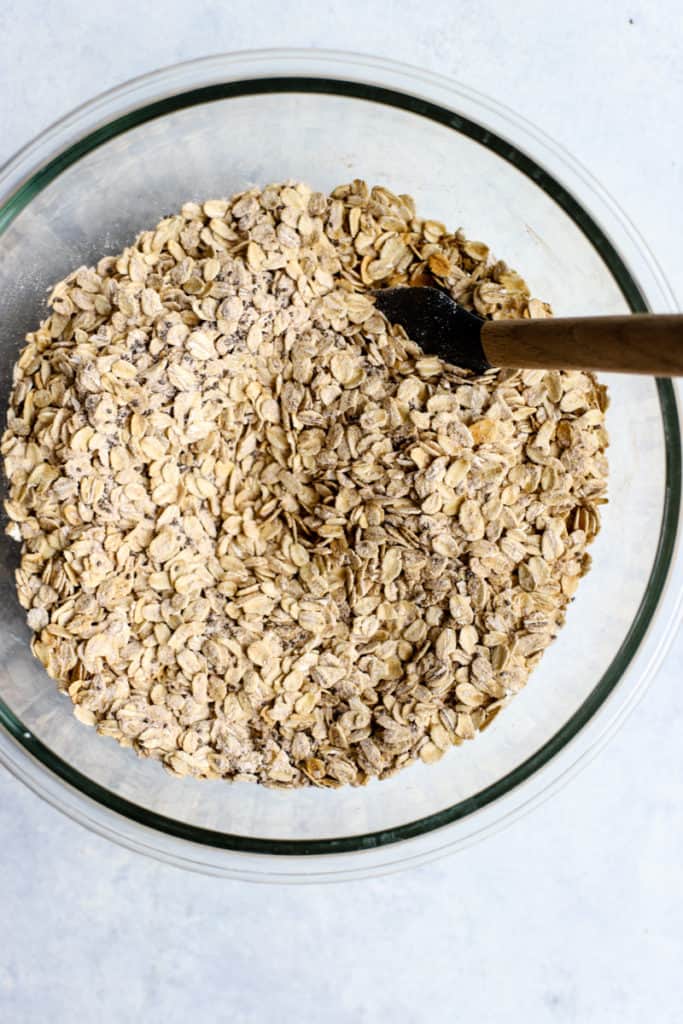 Oats, flour, chia seeds, cinnamon, and salt in a clear glass bowl, stirred together