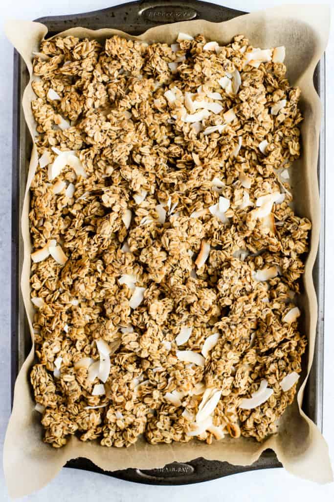 Simple coconut chia granola on parchment paper lined sheet pan