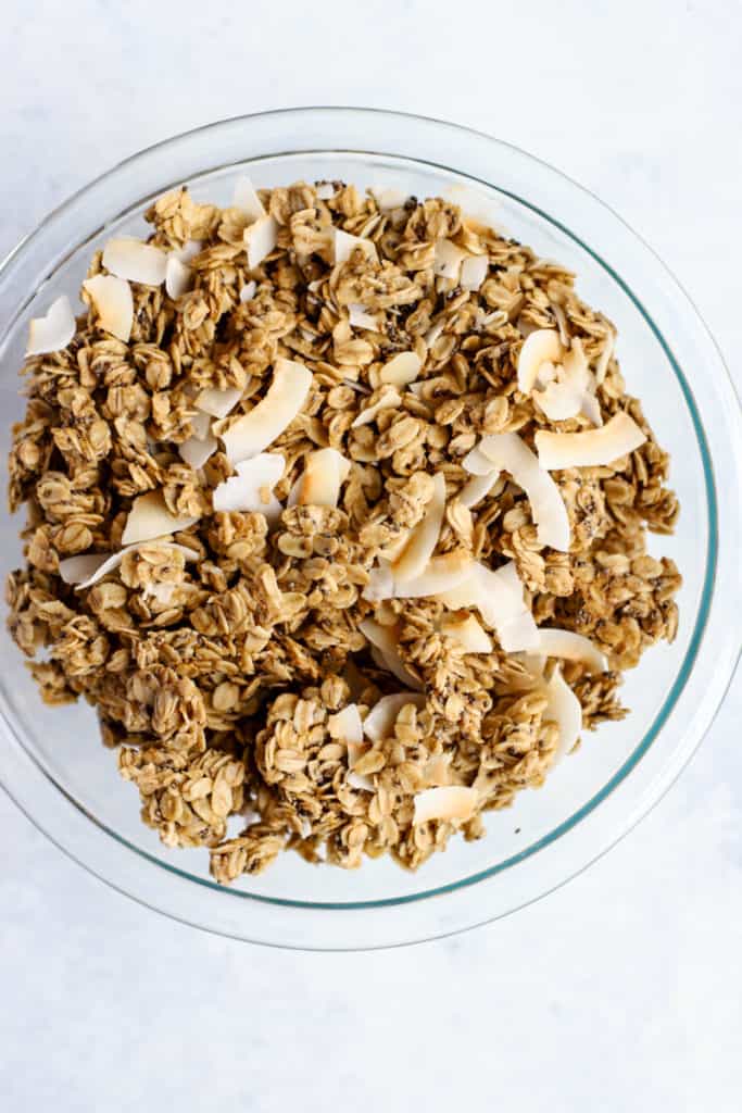 Simple coconut chia granola on parchment paper lined sheet pan