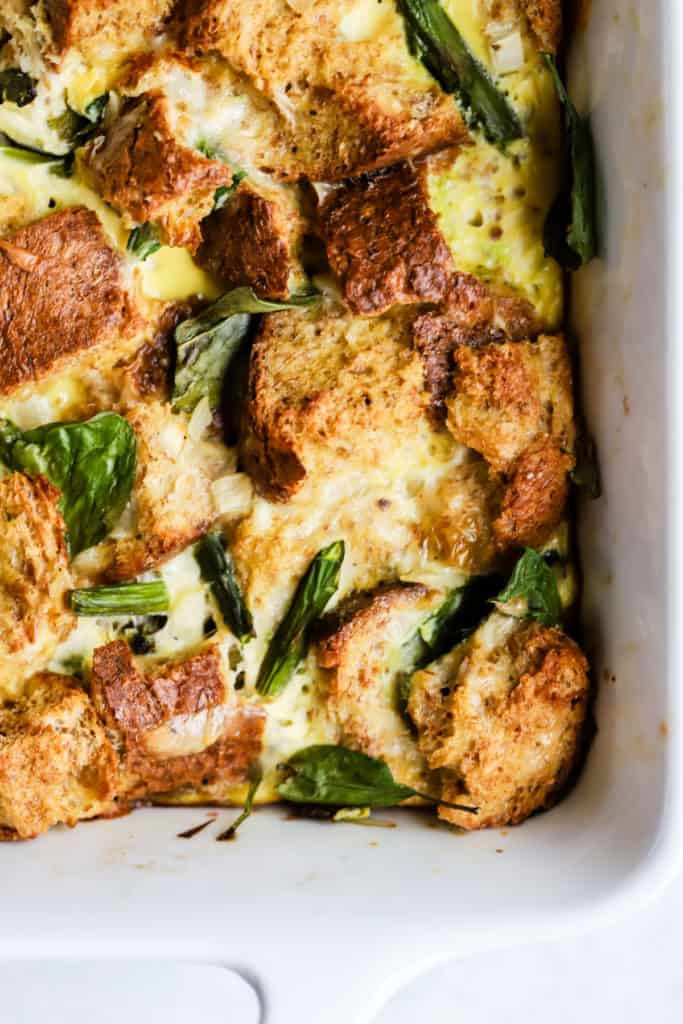 Fully baked spring veggie breakfast strata in white ceramic baking dish