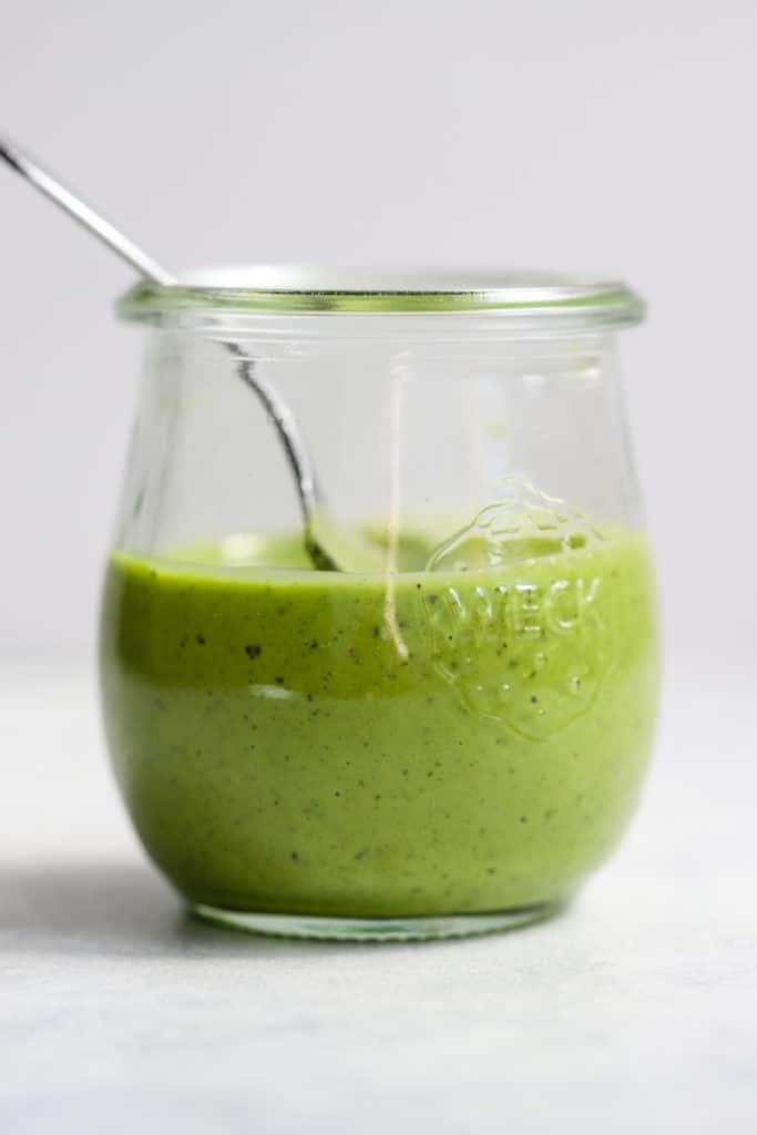 Homemade basil vinaigrette in small Weck jar with spoon